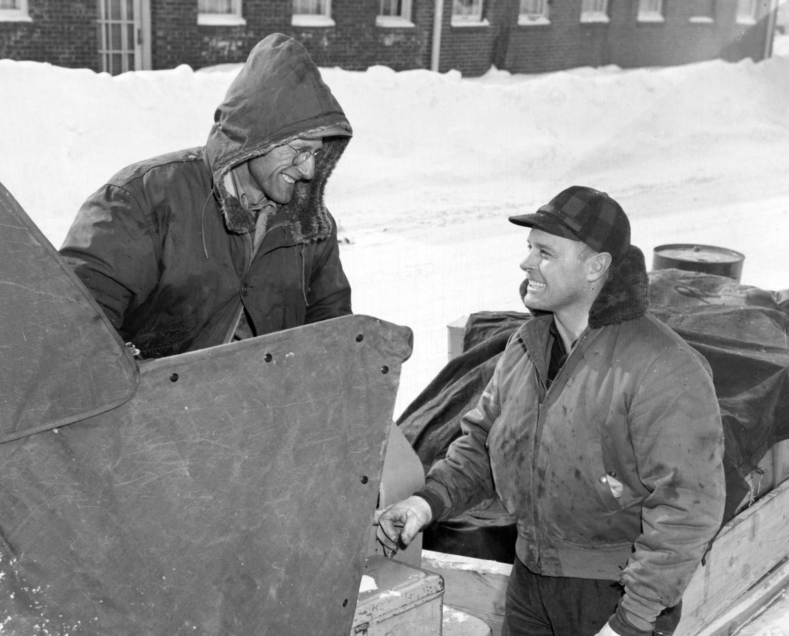 Harris Harmon (left) and Dick Tomlinson helping neighbors at 3 miles an hour in O'Neill. Published Feb. 5, 1949.